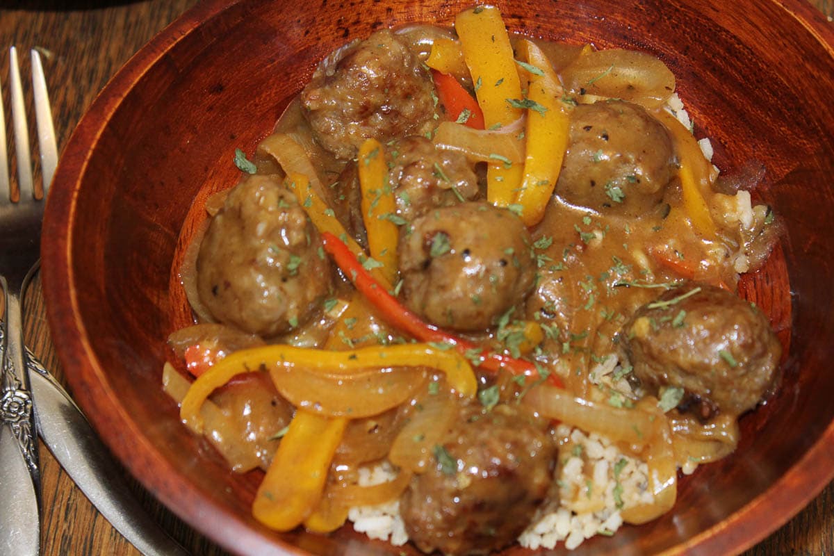 Italian sausage and peppers over rice in wooden bowl
