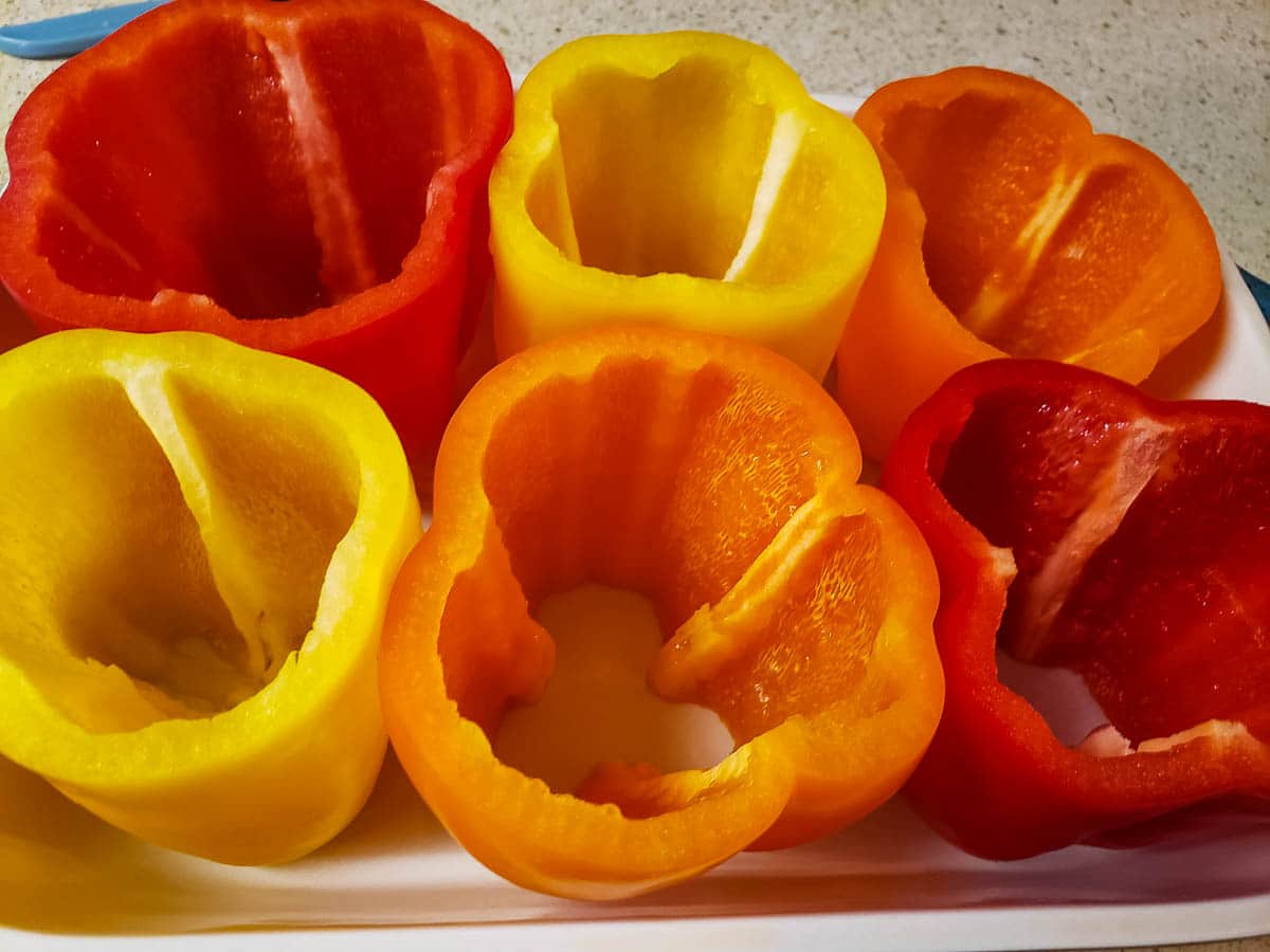 yellow, red, and orange bell peppers cleaned out in baking dish
