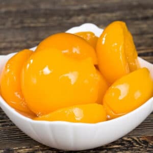 canned peaches in white bowl
