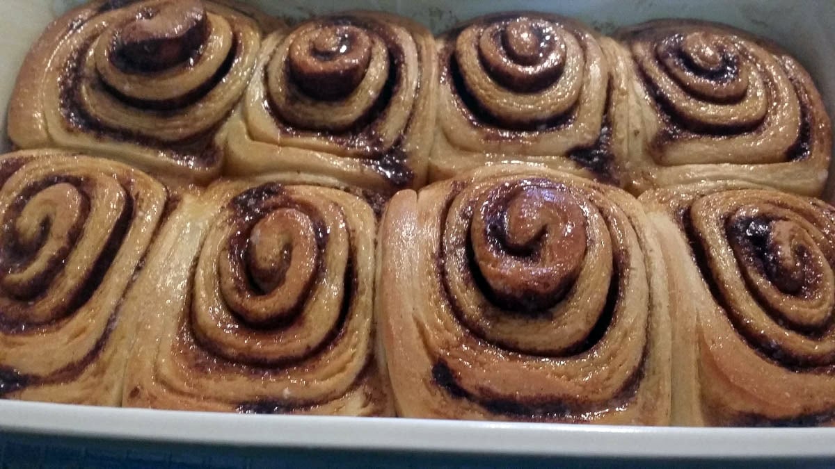 baked sourdough cinnamon rolls brushed with butter