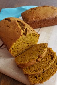 Sliced sourdough pumpkin bread on wooden cutting board