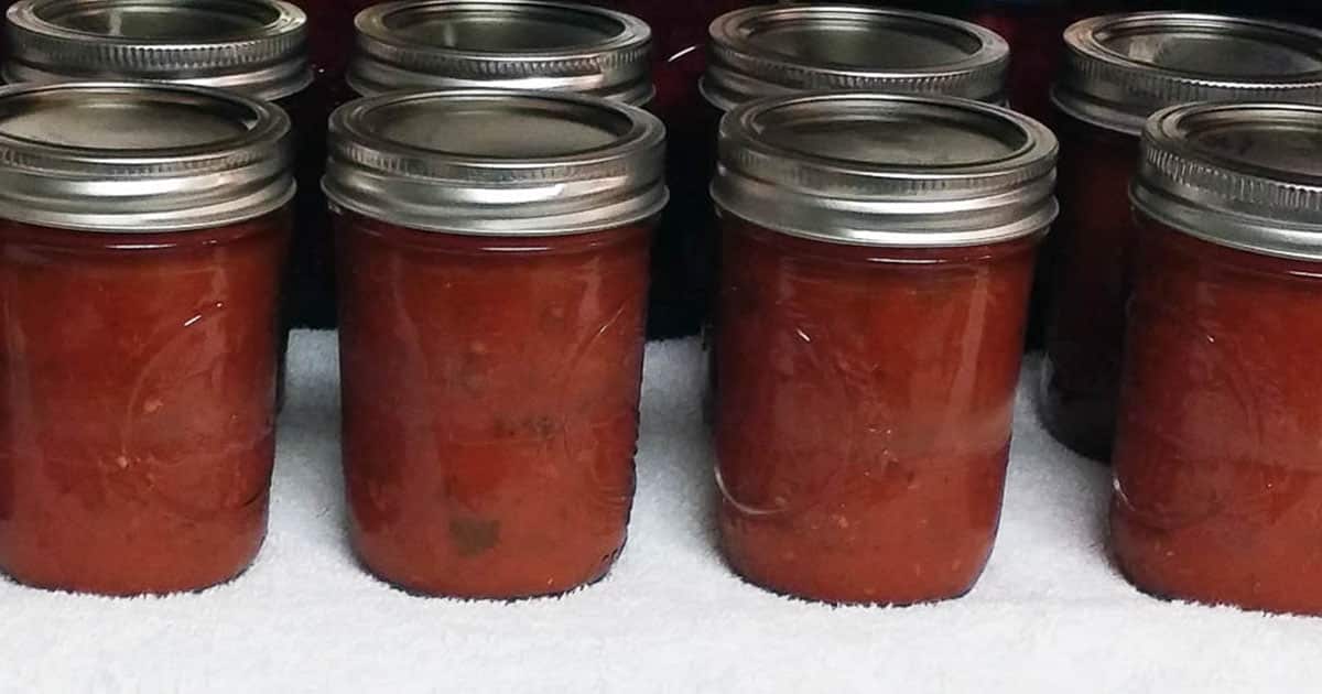 jars of canned pizza sauce on white towel