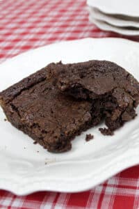 brownie on white plate on red and white tablecloth