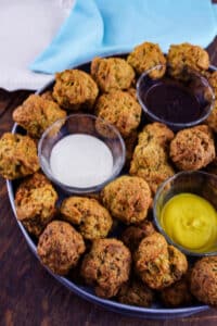 sausage balls with dipping sauces on metal tray.