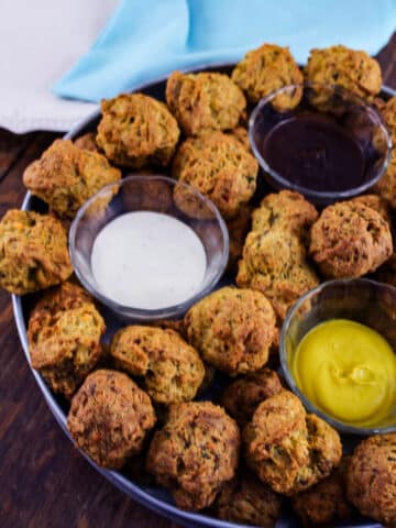 sausage balls with dipping sauces on metal tray.