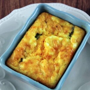 Asparagus and Eggs baked in blue rectangle dish on white plate.