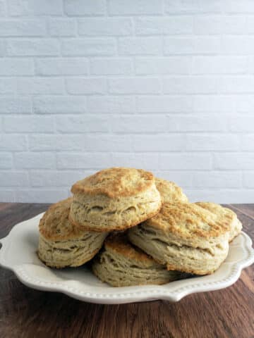 Buttermilk Biscuits on white plate on wooden table.