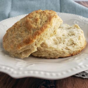 Split buttermilk biscuit on white plate.
