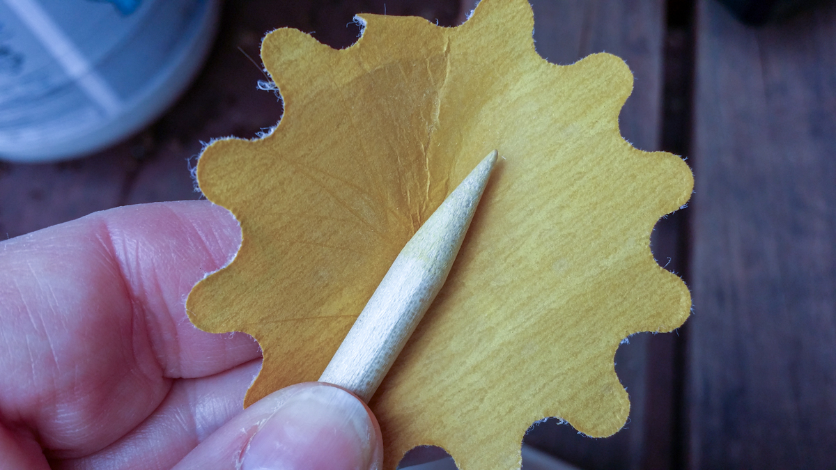 Sanding the pointed end of the dowel.
