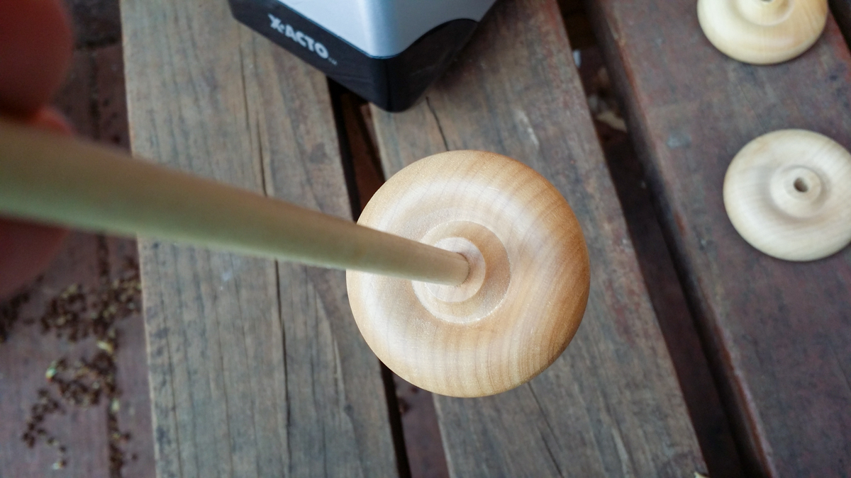 Wooden dowel inserted into wooden wheel.