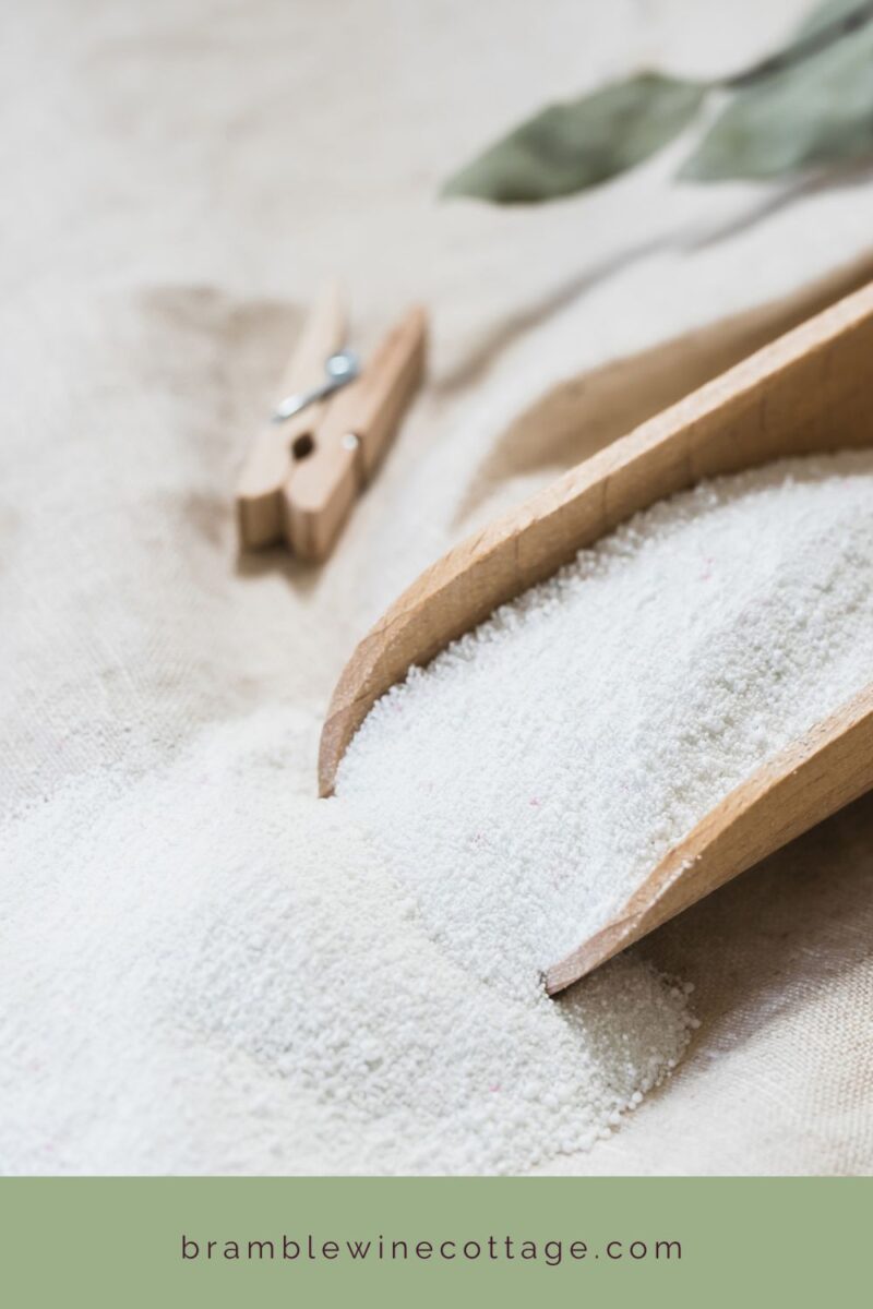 Homemade laundry powder with wooden scoop and clothes pins.
