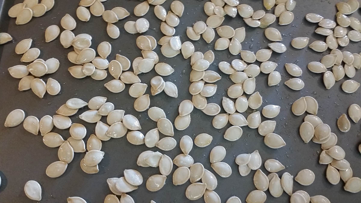 Pumpkin seeds on baking sheet.